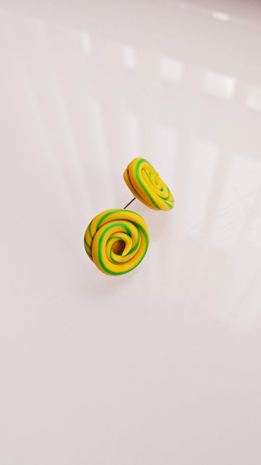 Green and yellow spiral earrings on a white background